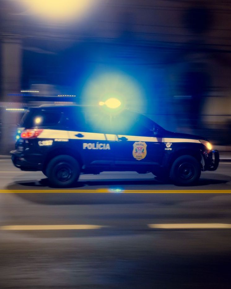 Police car speeding through a city at night