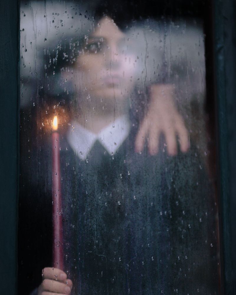 A face seen through a rain-covered window